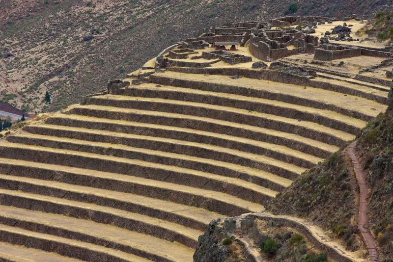 The Inca terraces at Pisac, stone steps climbing a green hillside.